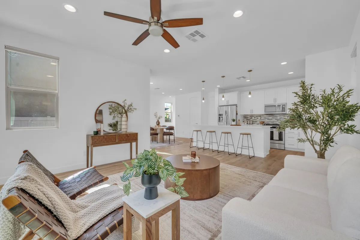 Bright, professionally staged open-concept living room and kitchen in a home for sale in North San Diego County
