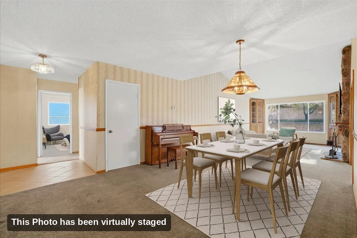 Virtually staged dining area open to the living room with a pendant light in a Rancho Peñasquitos home