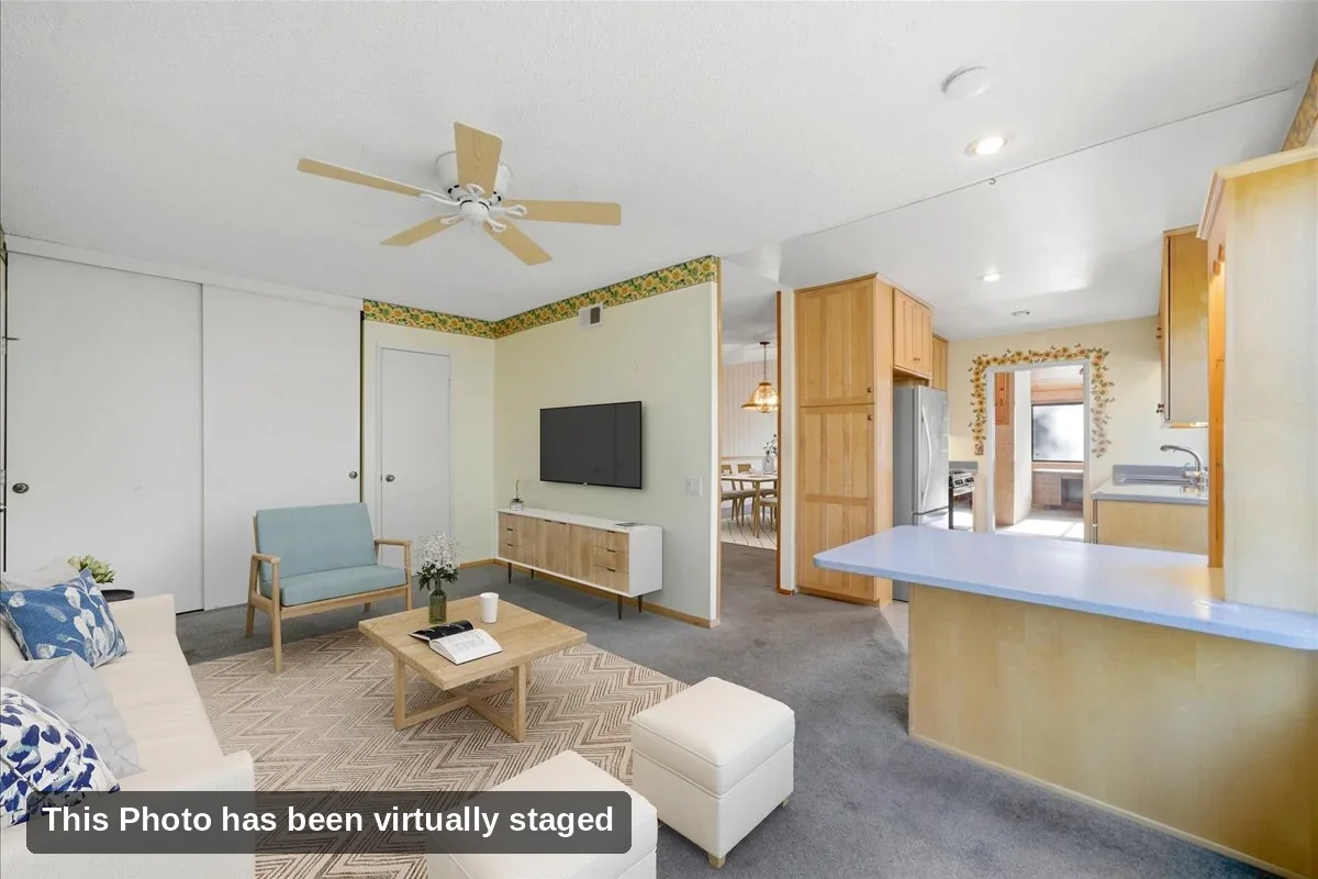 Virtually staged family room with ceiling fan open to the kitchen breakfast bar in a Rancho Peñasquitos home