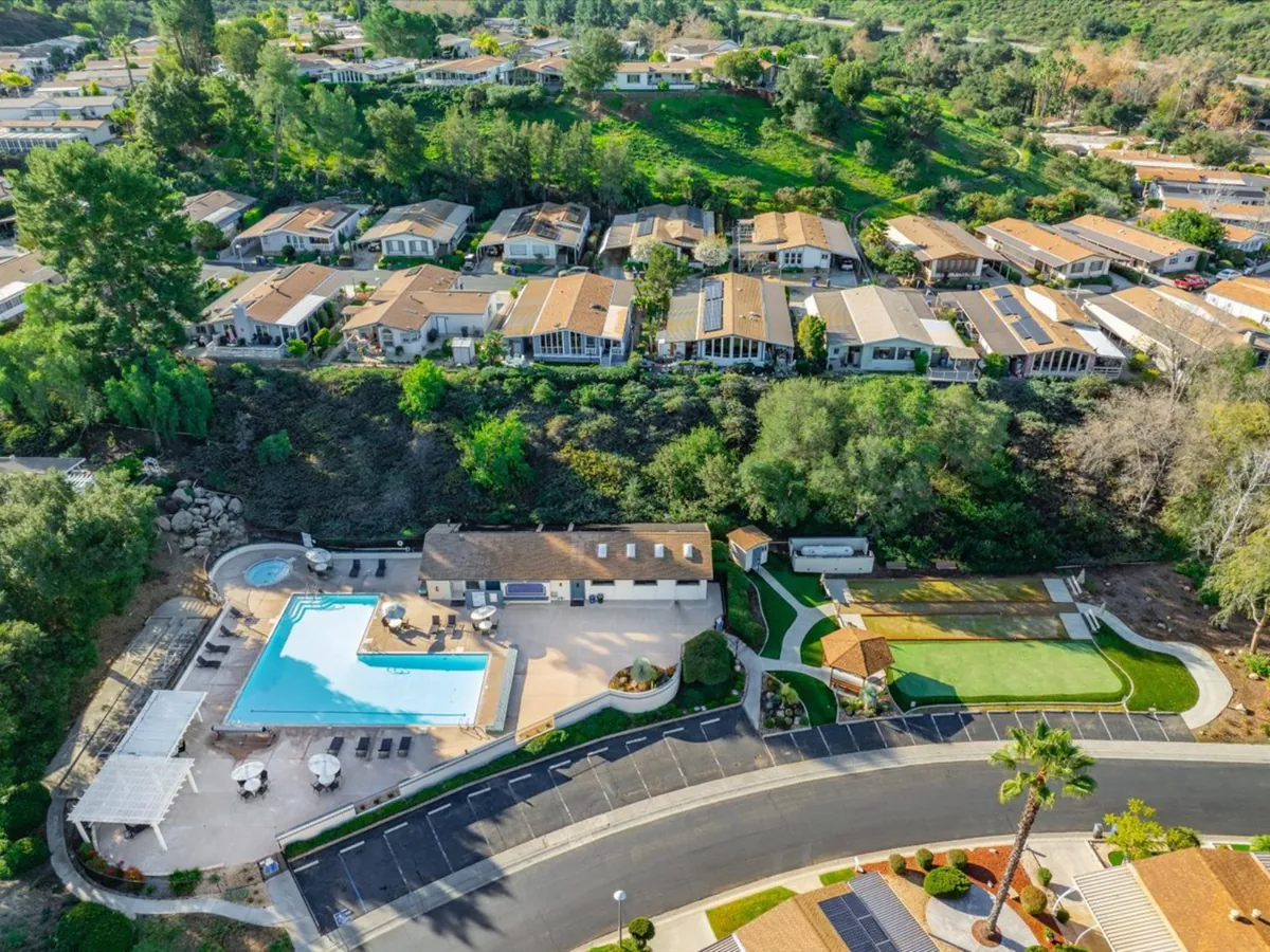Aerial view of a North County San Diego neighborhood with a community pool and green hillsides