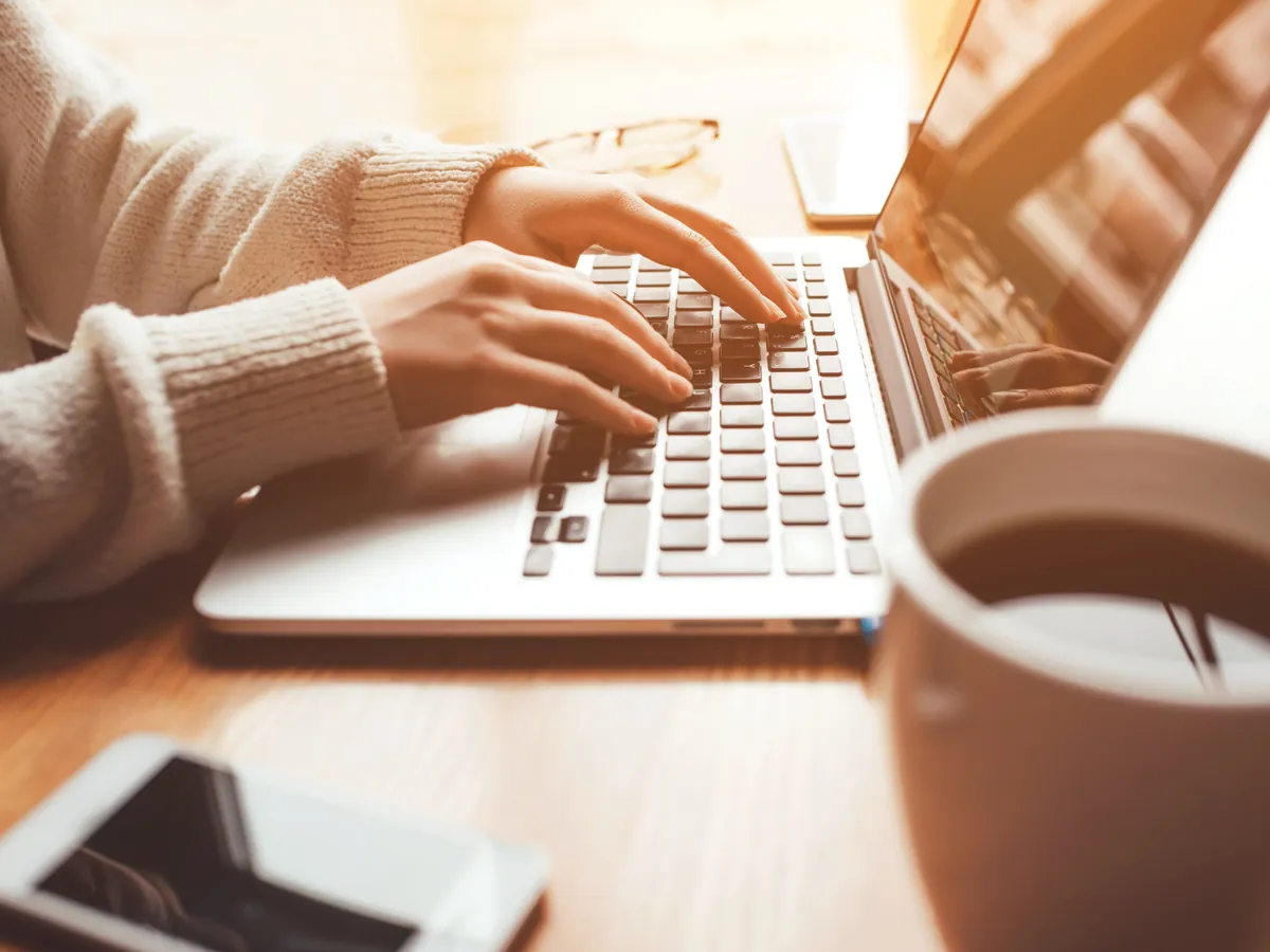 Home buyer reviewing their budget on a laptop with a cup of coffee