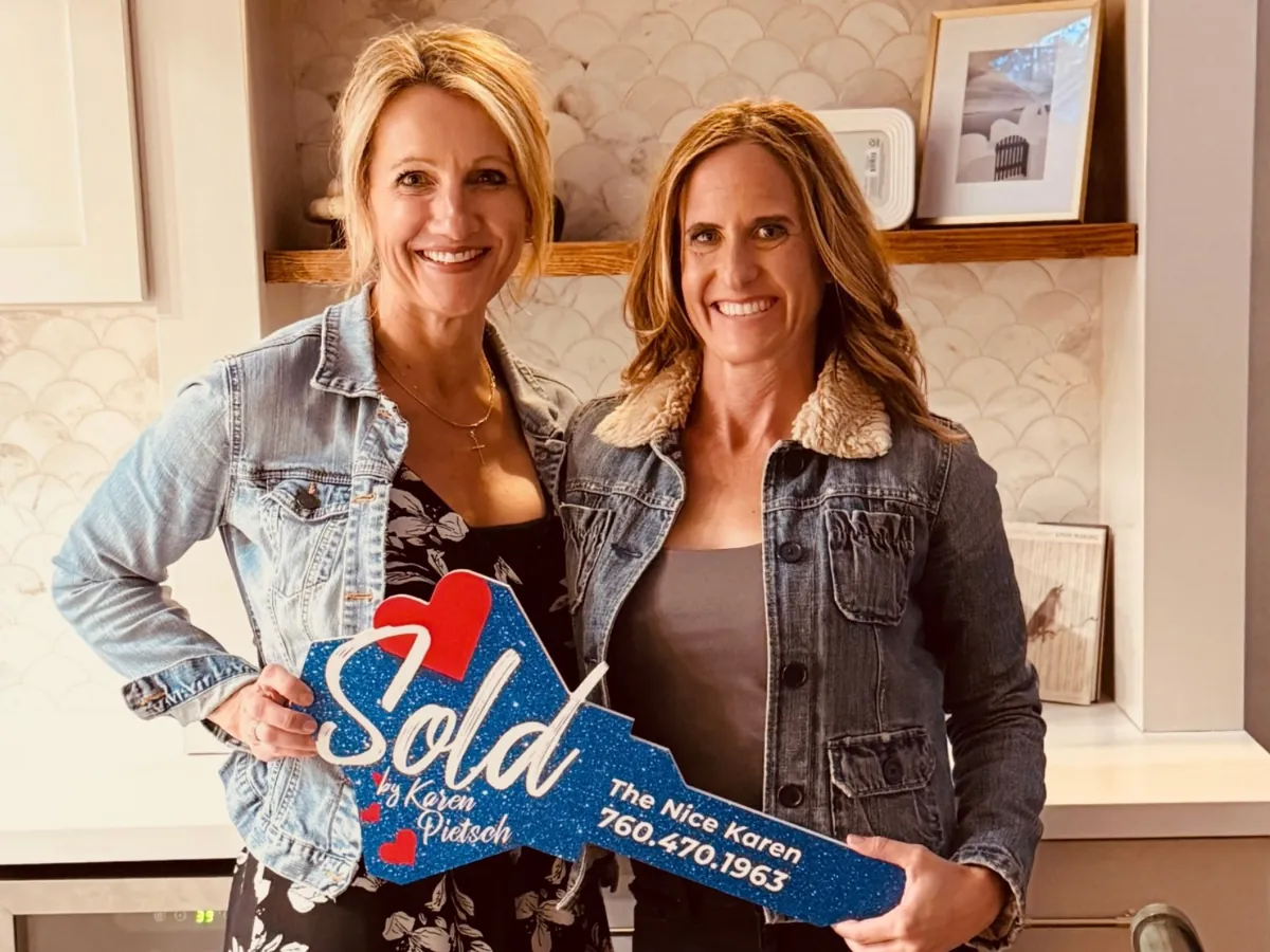 Karen Pietsch celebrating closing day with a client holding a Sold key sign