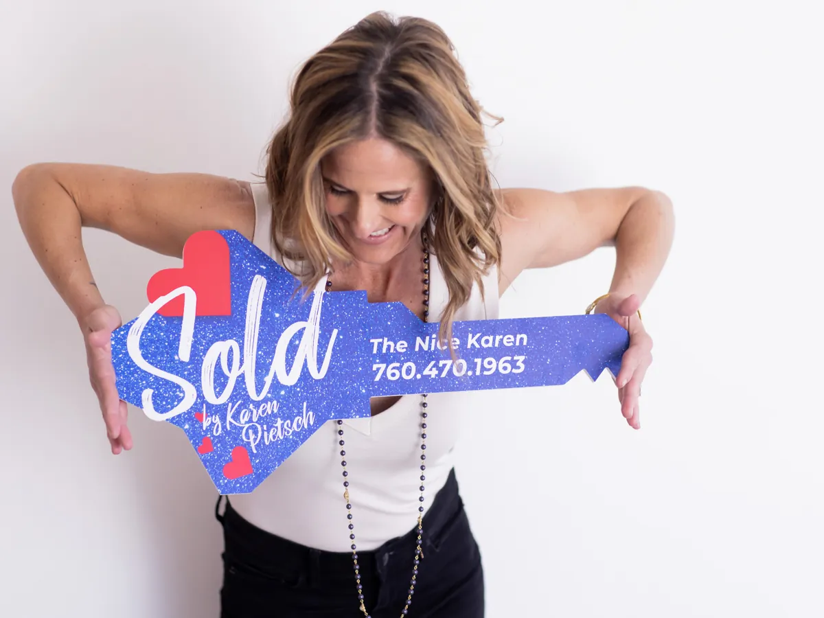Karen Pietsch holding her Sold by Karen Pietsch key sign