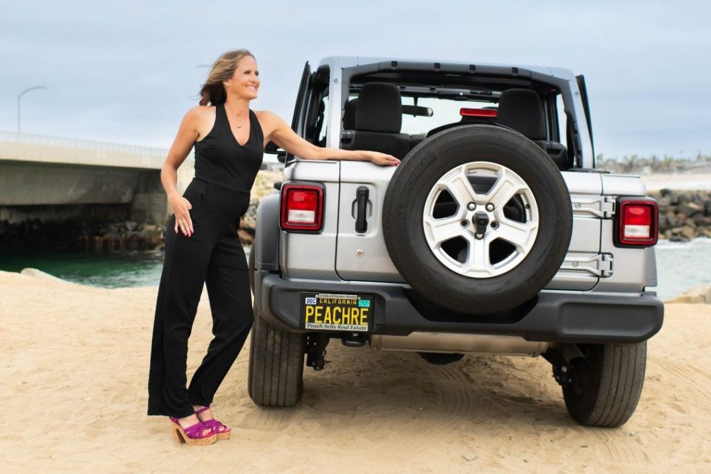 Karen Pietsch, North County San Diego REALTOR, standing beside her Jeep on the beach