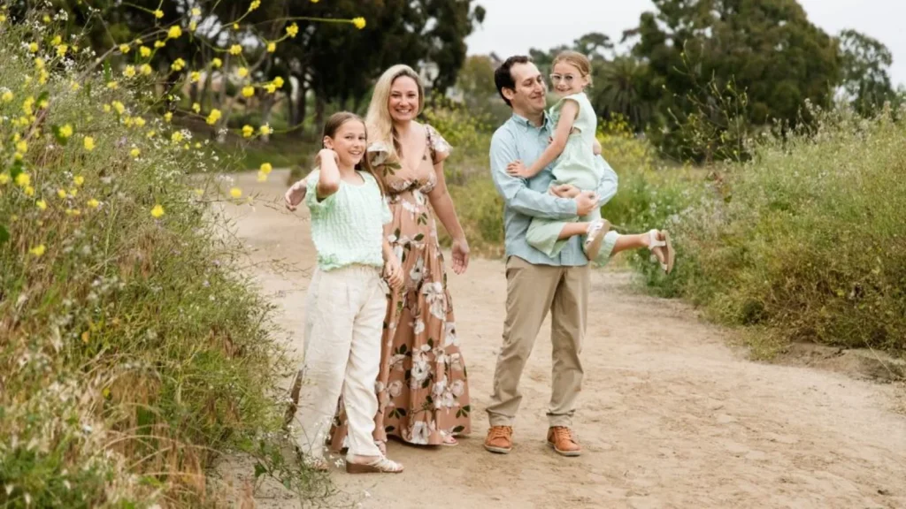 Family walking a wildflower-lined dirt hiking trail in North County San Diego
